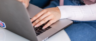 woman sits at table working on laptop